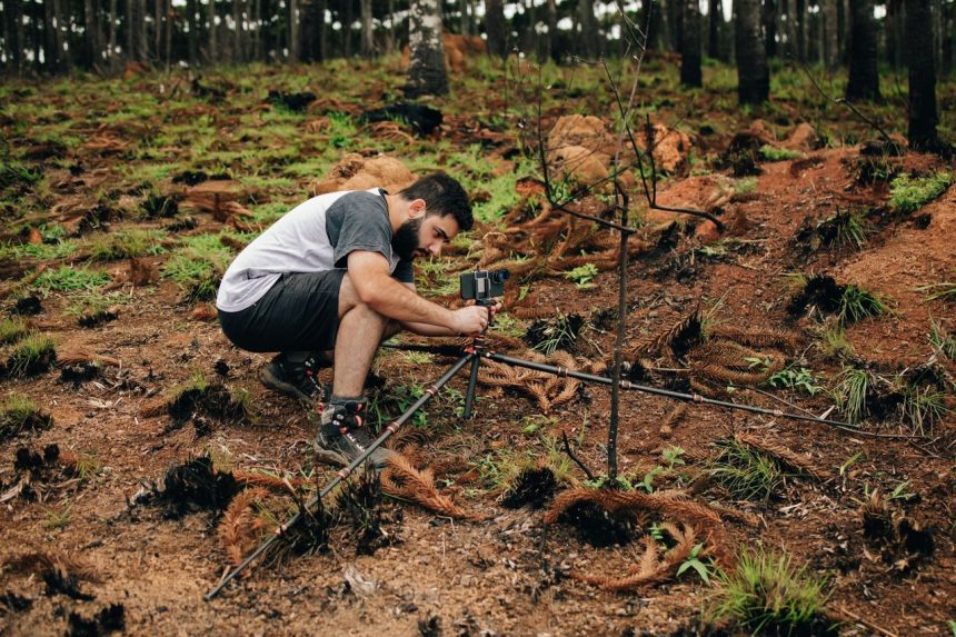 Pesquisador instala equipamentos para realizar pesquisa ambiental em uma área de vegetação.