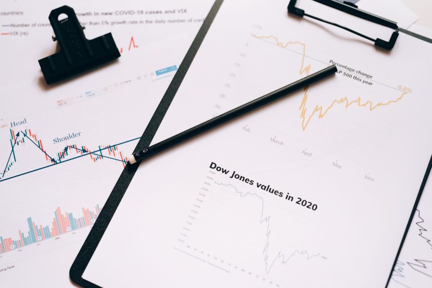 Prancheta com gráficos e dados do mercado financeiro, ilustrando a análise da economia.